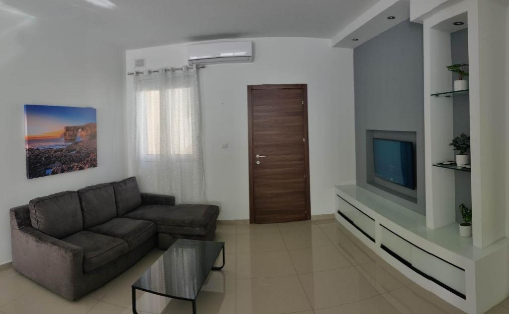 a living room with a couch and a television at Seron Apartment 3 in St. Paul's Bay