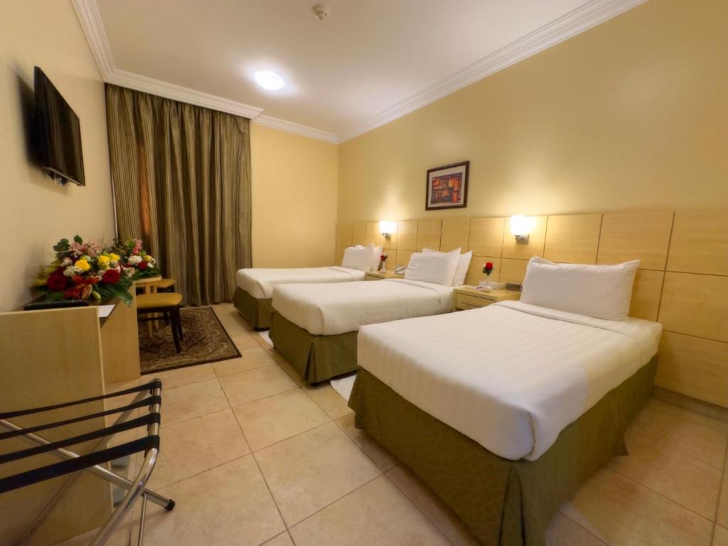  فندق بدر الماسه في مكة المكرمة: غرفة فندق فيها سريرين وورود