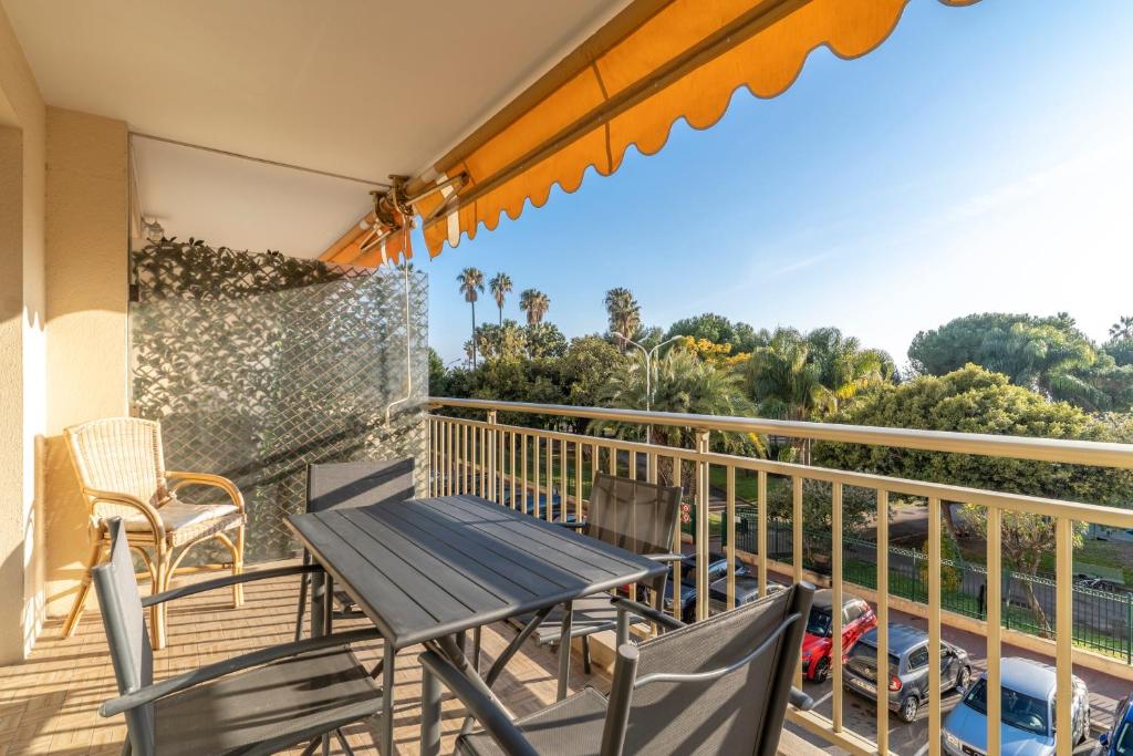 un patio avec une table et des chaises sur un balcon dans l'établissement Le Mistral - Appt avec deux balcons à Cannes, à Cannes