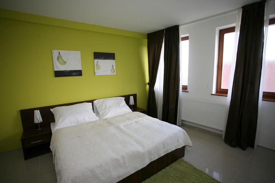 sypialnia z białym łóżkiem i zieloną ścianą w obiekcie Grand hotel/pension w mieście Sládkovičovo