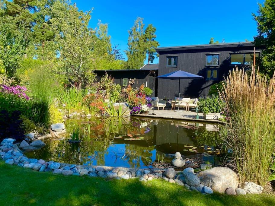 a garden with a pond in the yard at Orres Guesthouse Stenhamra, Ekerö in Stenhamra