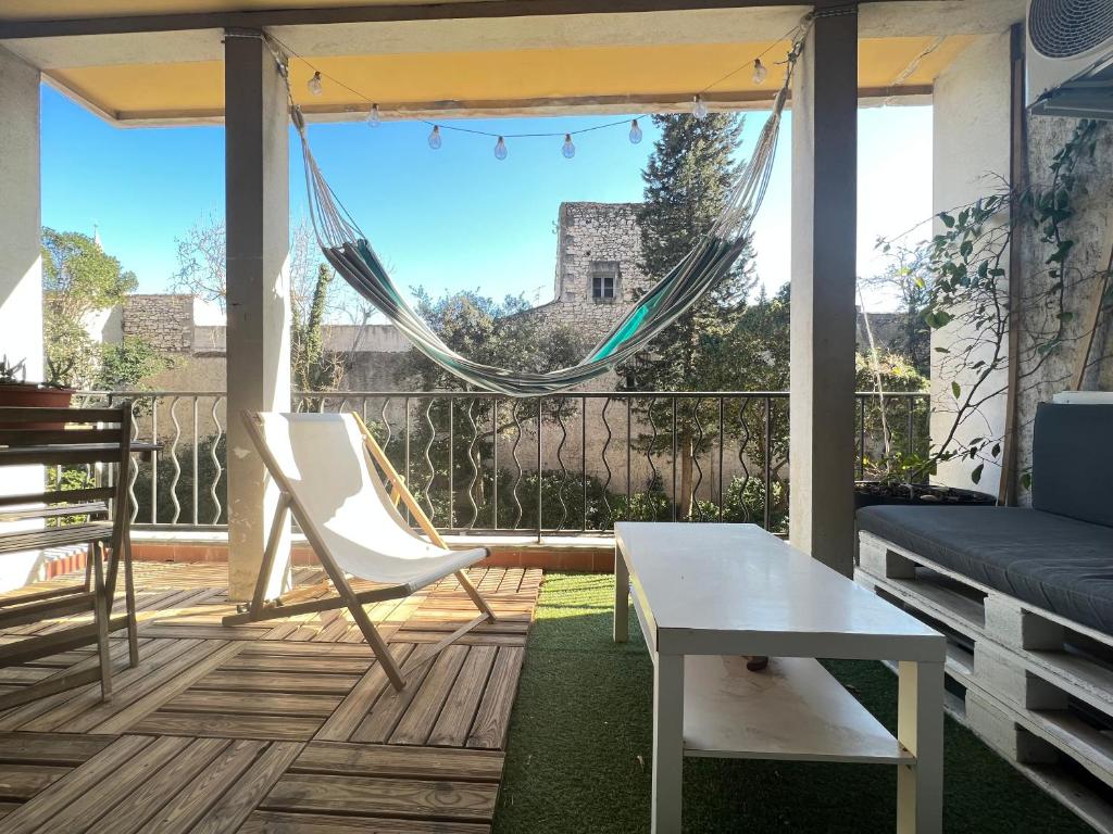 a balcony with a hammock and a table and chair at Superbe appartement centre ville in Nîmes