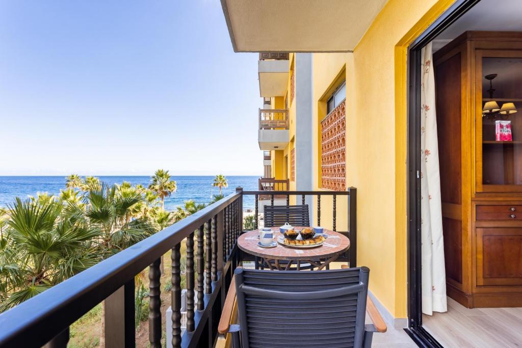 d'un balcon avec une table et des chaises donnant sur l'océan. dans l'établissement Home2Book Caletillas Beach Naiguata,Wifi & Terrace, à Candelaria