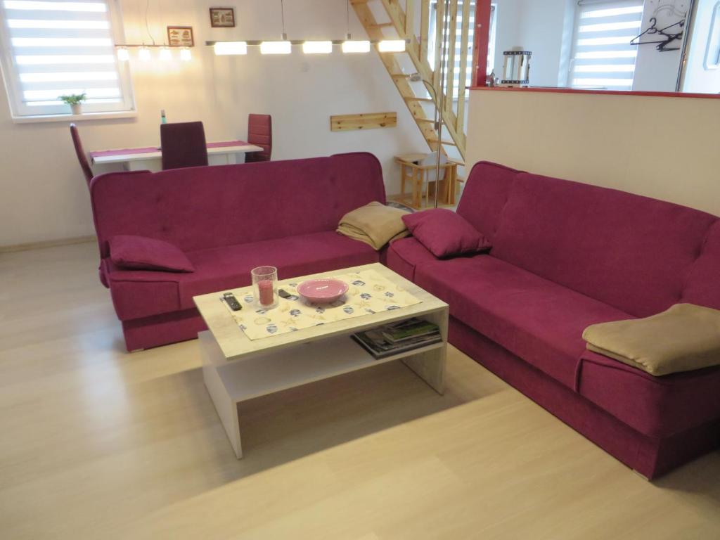 a living room with a purple couch and a table at Neu Haus Koralle an der Nordsee in Dornumergrode