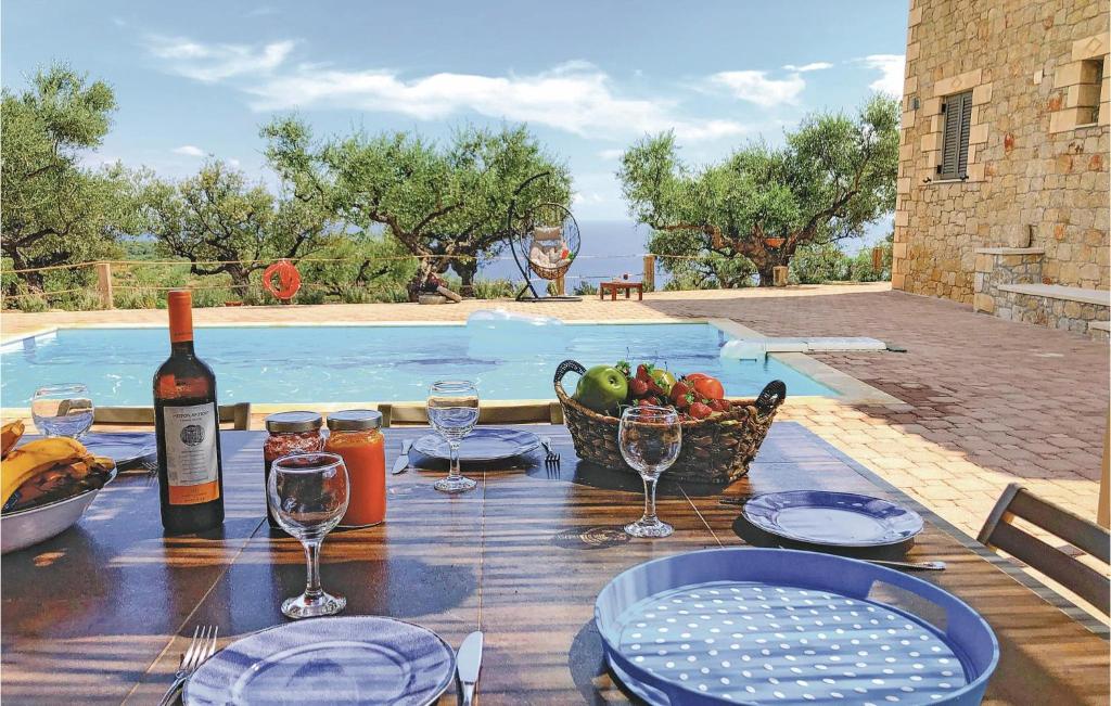 - une table avec une bouteille de vin et une corbeille de fruits dans l'établissement Stunning Home In Kardamyli With Wifi, à Kardamyli
