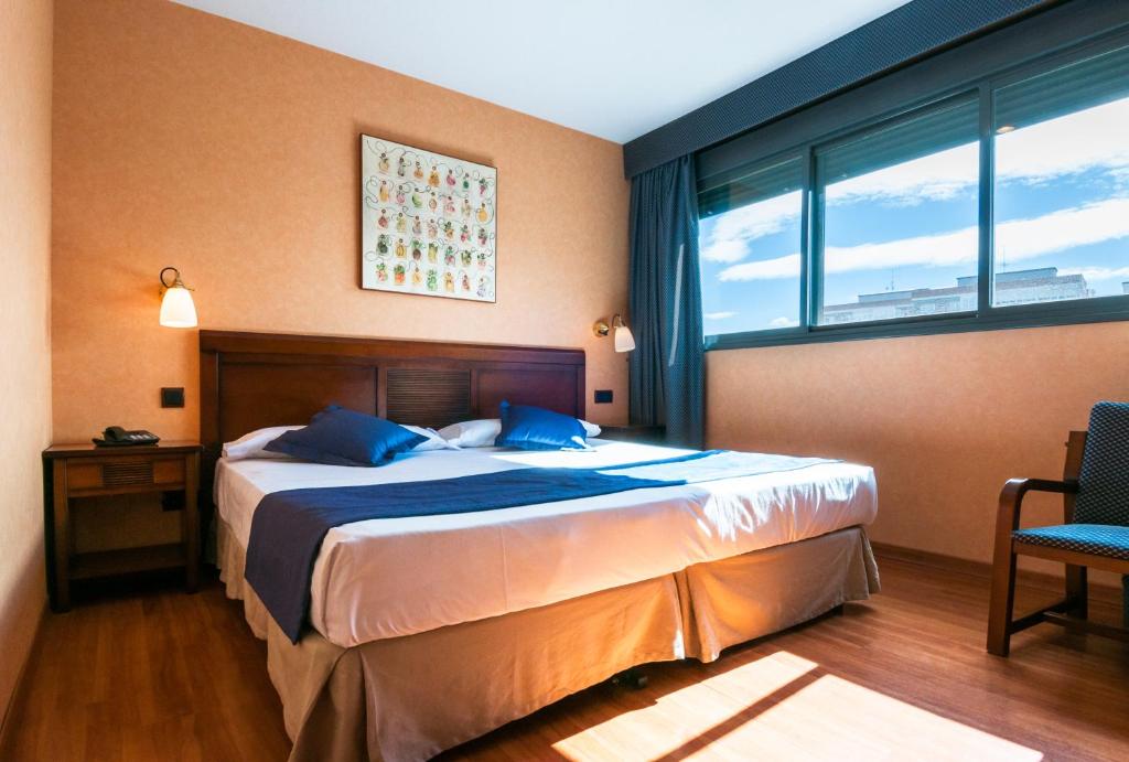 um quarto com uma cama e uma grande janela em Hotel Las Provincias em Fuenlabrada