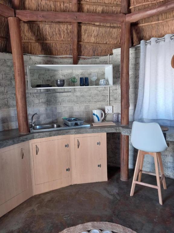 uma cozinha com um lavatório e um banco num quarto em Slypsteen Guest Farm em Sternham