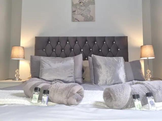 a bedroom with a large white bed with two lamps at Serene getaway Apartments in Maidstone