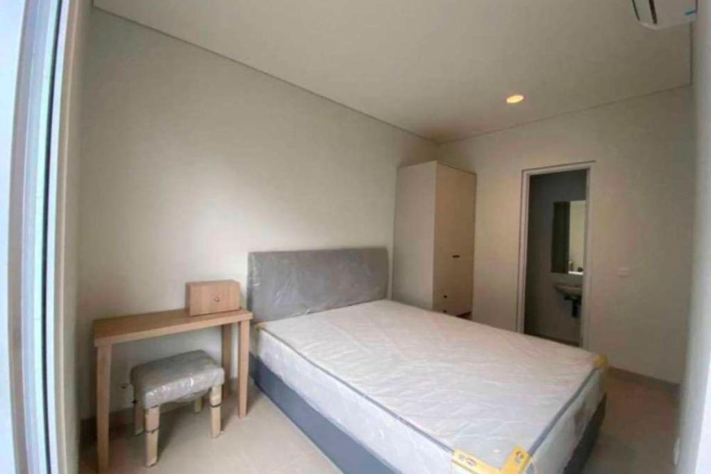 a small bedroom with a bed and a table at EXPRESS O 92155 Nia Residence 2 in Tegal