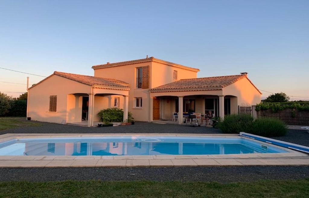 Villa con piscina frente a una casa en Le Chant du Moulin - Maison avec piscine, en La Caillère