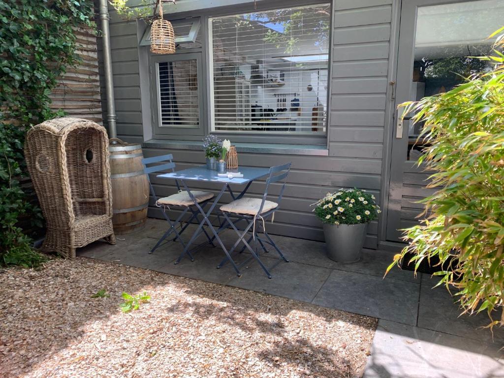 a patio with a table and chairs and a window at Appartement 't Zomerhuis in Zandvoort