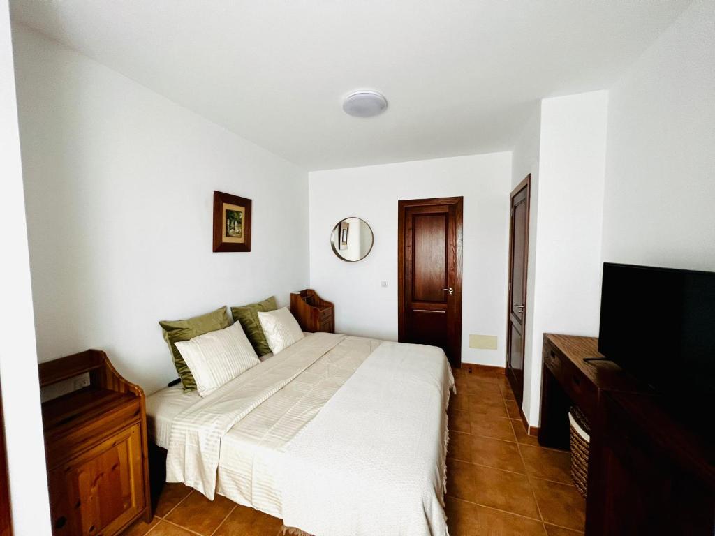 um quarto com uma cama e uma televisão de ecrã plano em Mi Villa em Playa Blanca