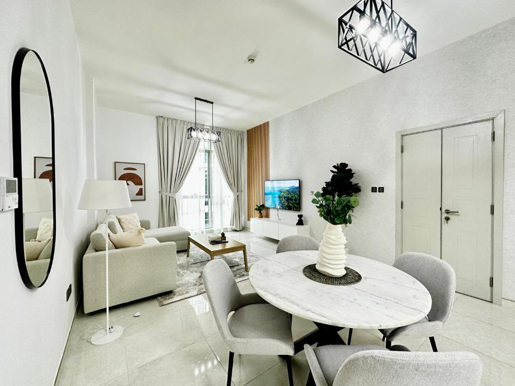 ein Wohnzimmer mit einem Tisch und Stühlen in der Unterkunft PR25 - Cozy 1BR in Polo Residences in Dubai