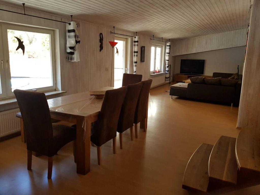 a living room with a wooden table and chairs at Zur alten Wagnerei in Rumbach