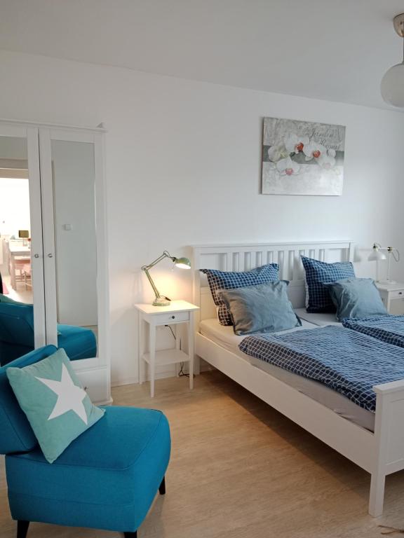 sypialnia z 2 łóżkami i niebieskim krzesłem w obiekcie Villa Cihelna apartments w Czeskim Krumlovie