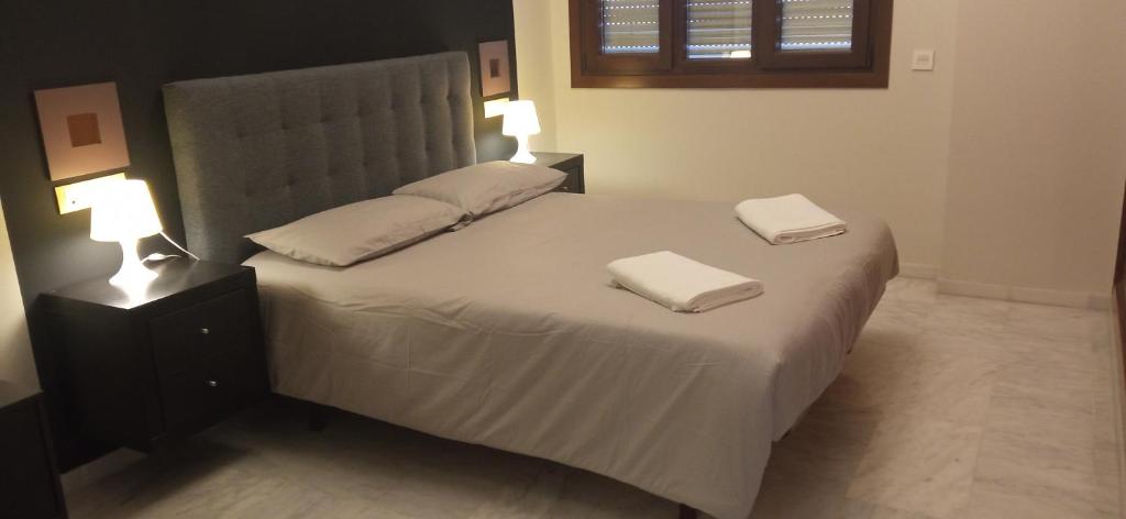 sypialnia z łóżkiem z dwoma ręcznikami w obiekcie FIBES Lux Sevilla Este. w Sewilli