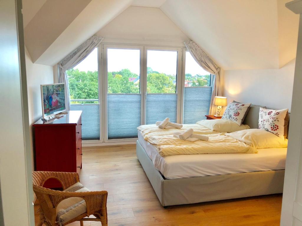 a bedroom with two beds and a large window at Maison du Port in Timmendorfer Strand