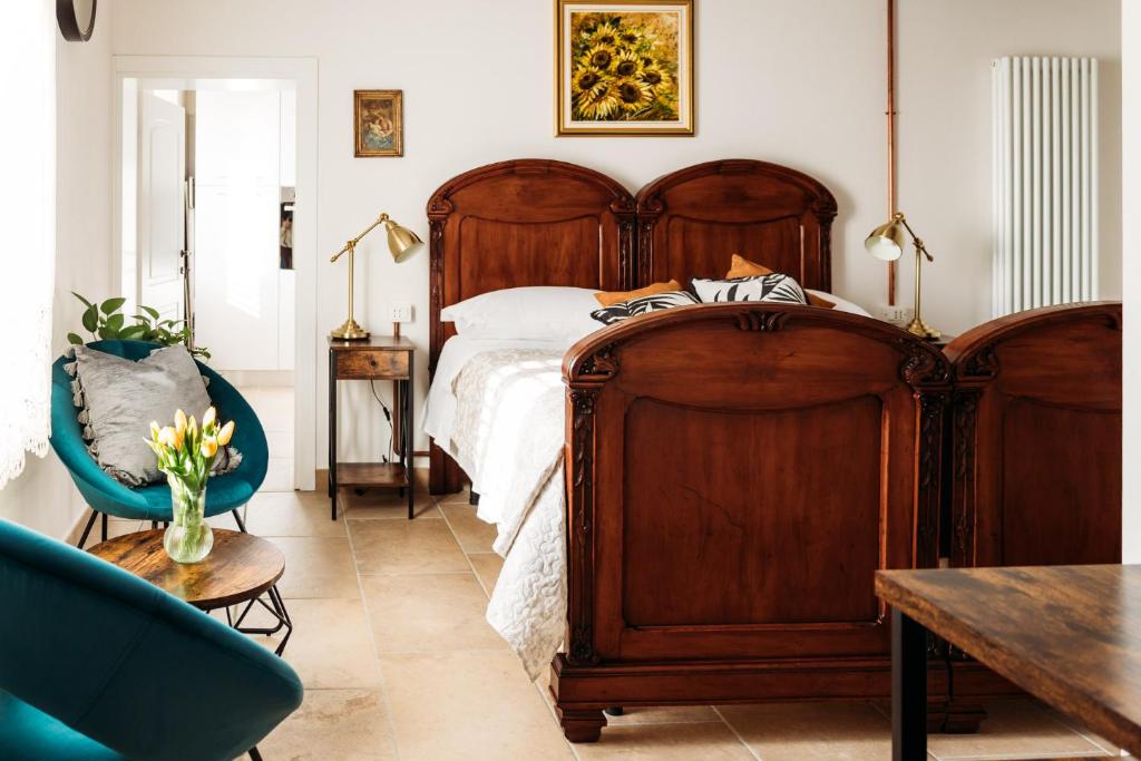 - une chambre avec un grand lit en bois et une chaise bleue dans l'établissement Casa Due Marie Marano sul Panaro, à Marano sul Panaro