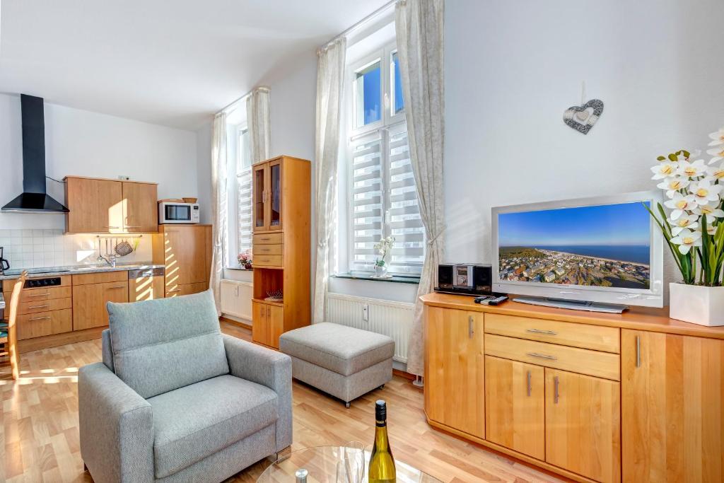 班辛海的住宿－Villa Frieda Wohnung 6，客厅配有椅子和电视