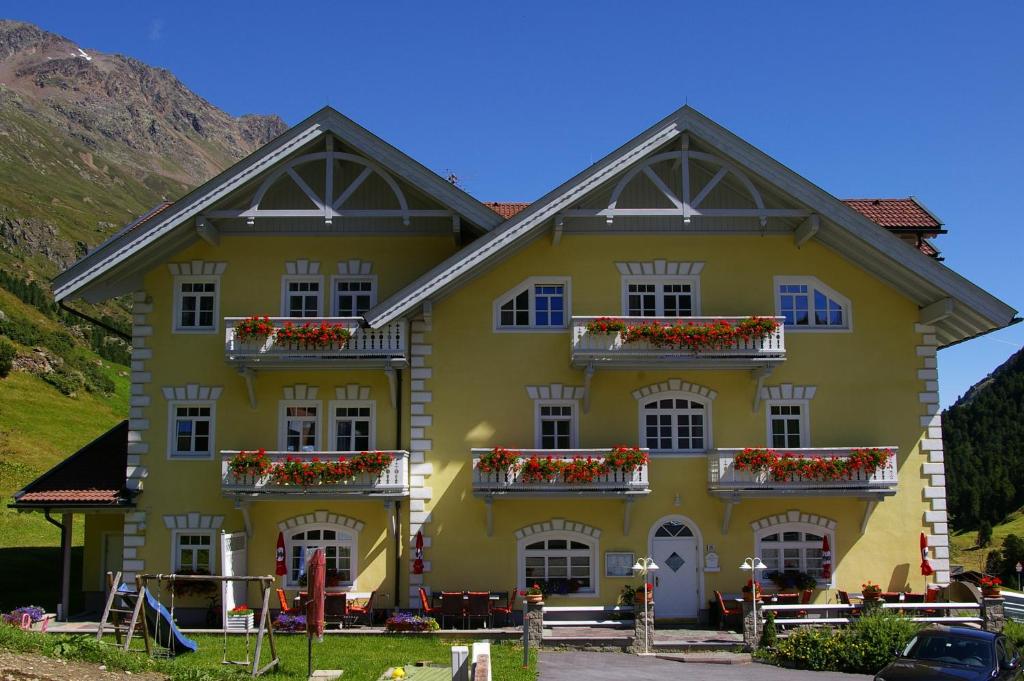 a yellow house with flowers on the balconies at Appartement Wildspitz' in Vent