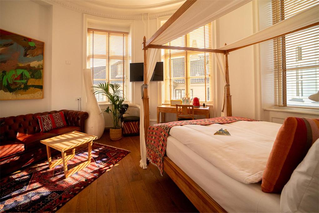 een slaapkamer met een bed en een bank bij Babette Guldsmeden in Kopenhagen
