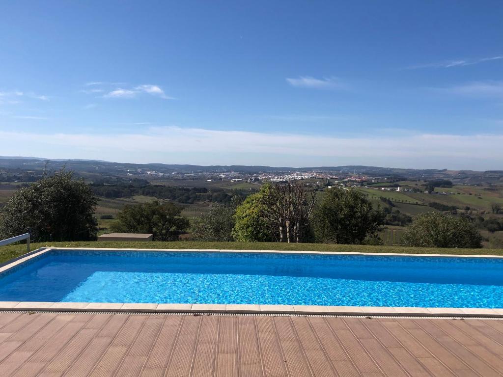 a swimming pool with a view of the hills at Casa do Horizonte in Bombarral
