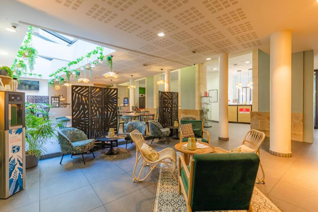 a lobby with chairs and tables in a building at Appart’City Confort Nantes Centre in Nantes