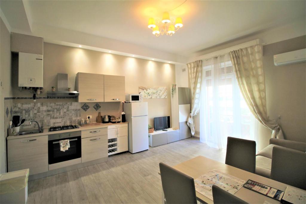 a kitchen with white cabinets and a table and a dining room at Secondopiano in Pisa