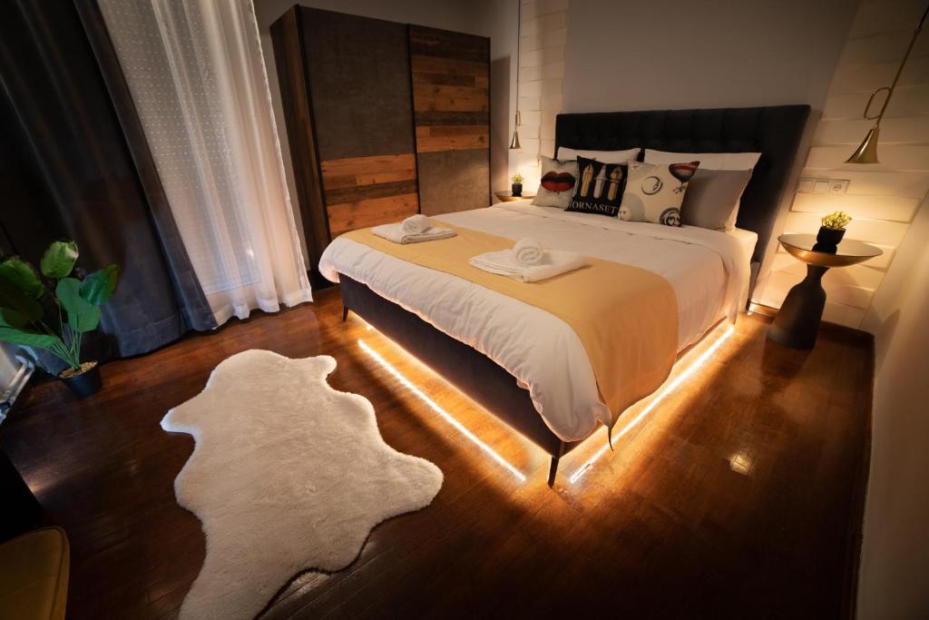 a bedroom with a large bed with a light on the floor at URBAN MAISON in Larisa