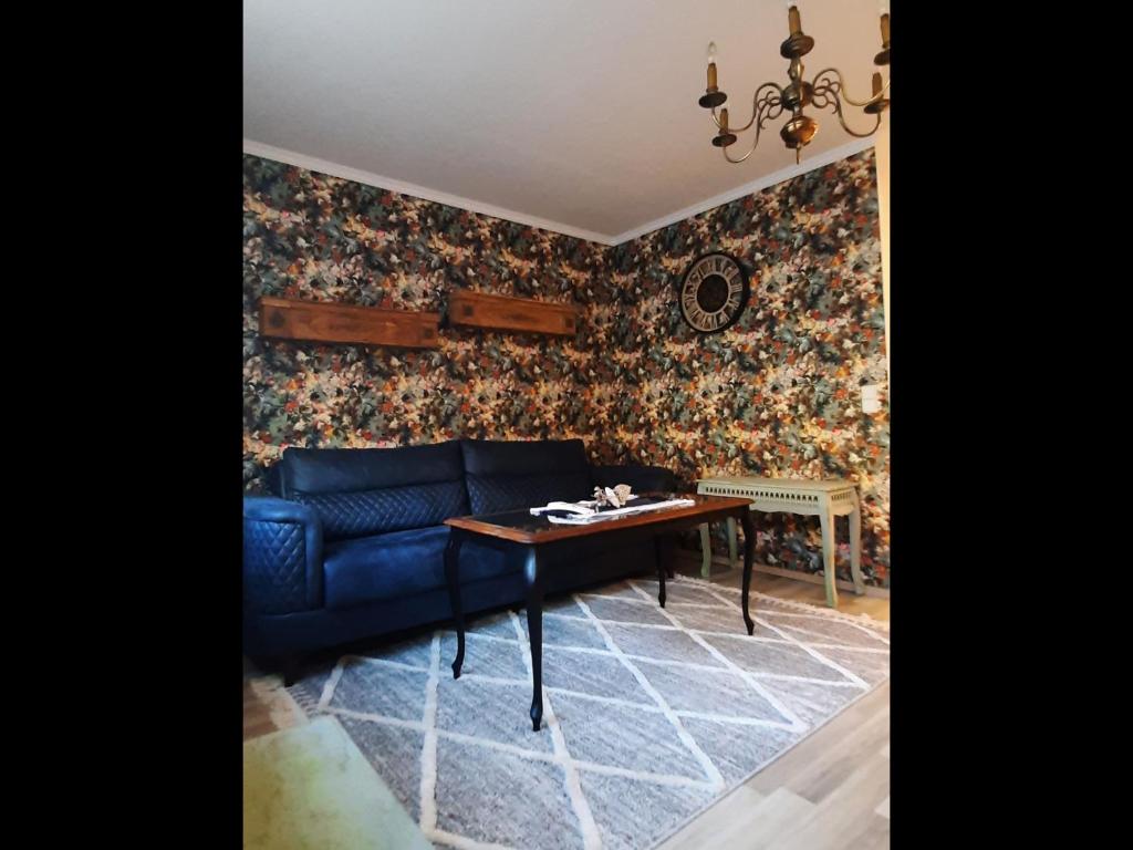 ein Wohnzimmer mit einem blauen Sofa und einem Tisch in der Unterkunft Zur alten Gurkeneinlegerei in Lübbenau