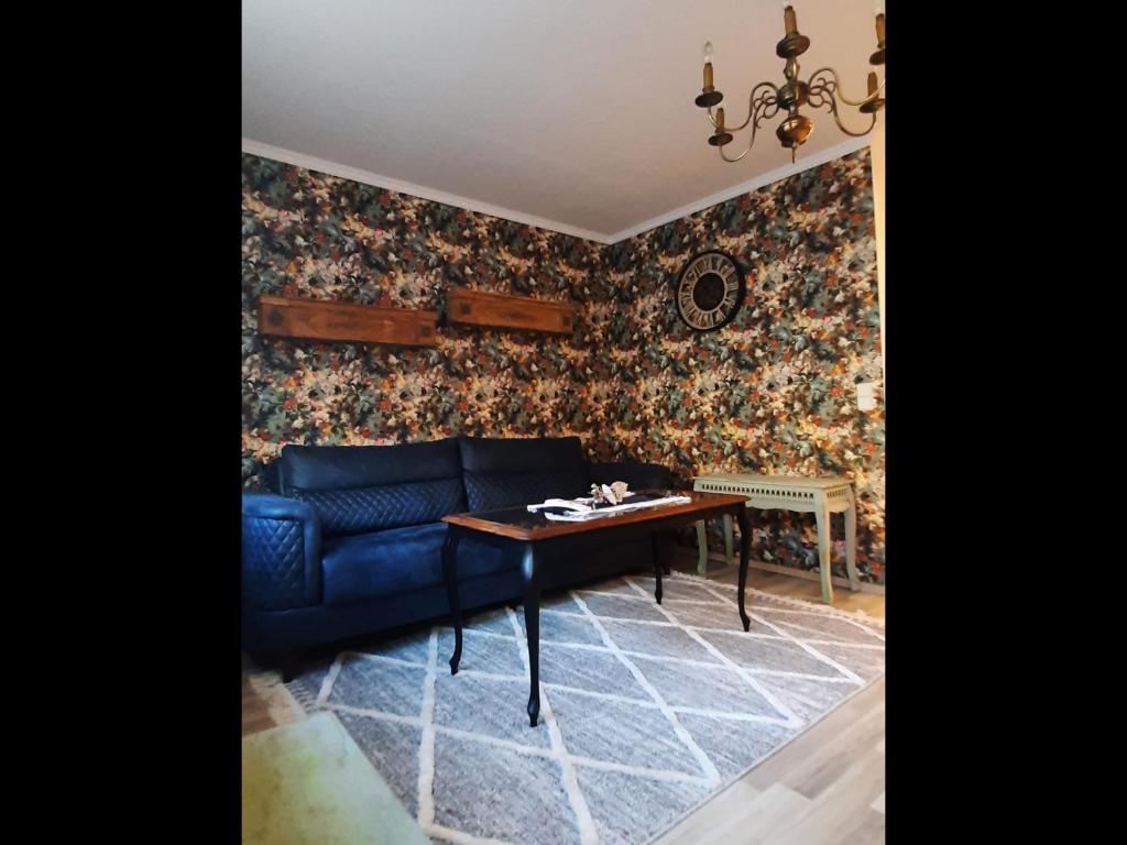 a living room with a blue couch and a table at Zur alten Gurkeneinlegerei in Lübbenau