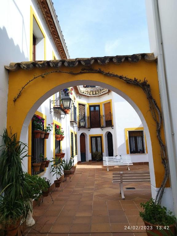 un arco en un edificio con bancos en un patio en Ático muy luminoso en el casco antiguo, en Córdoba