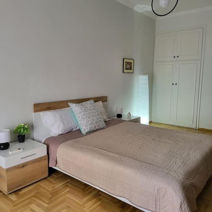 una camera con un grande letto e pavimenti in legno di GREAT APARTMENT IN VERIA a Veria