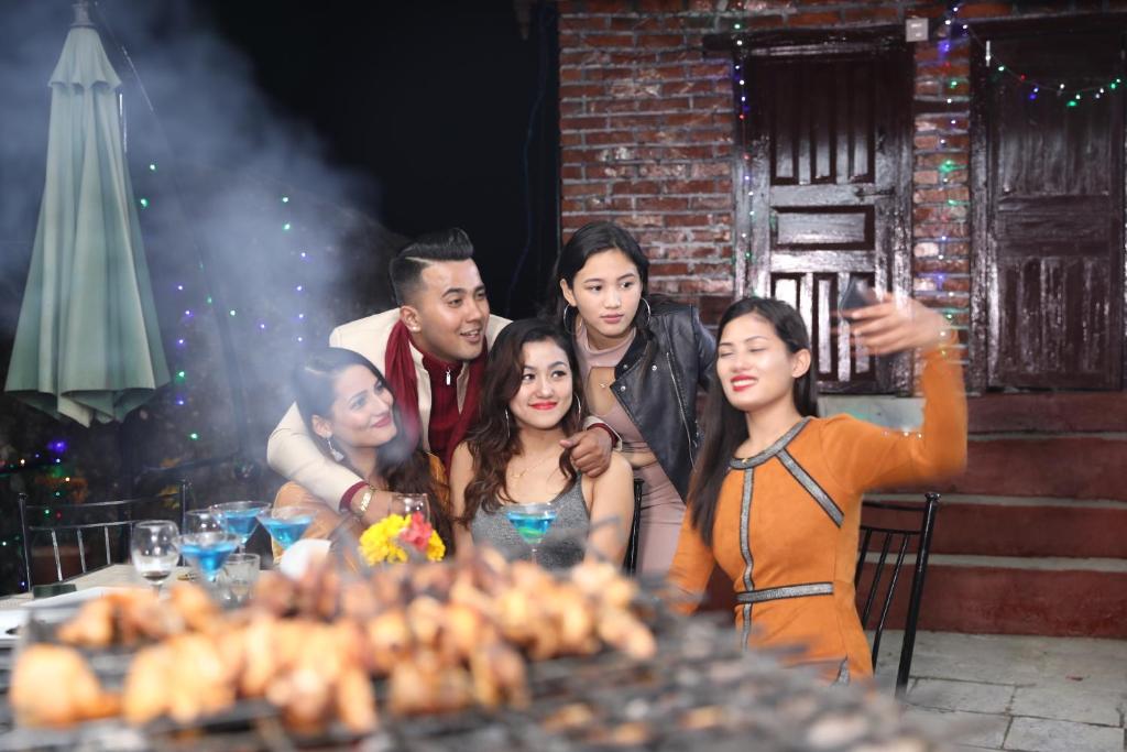 a group of people standing around a table with food at Rock Garden Resort in Pokhara