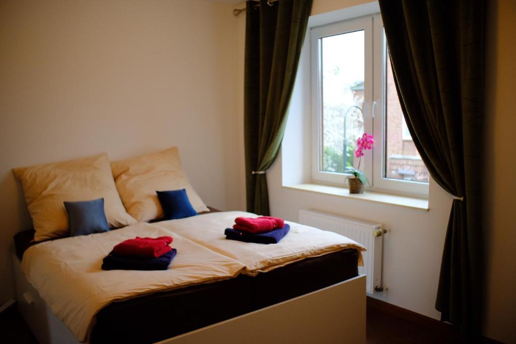 Un dormitorio con una cama con almohadas rojas. en zentral, Mini Suite zwei Räumen, Parks, Messe, en Düsseldorf