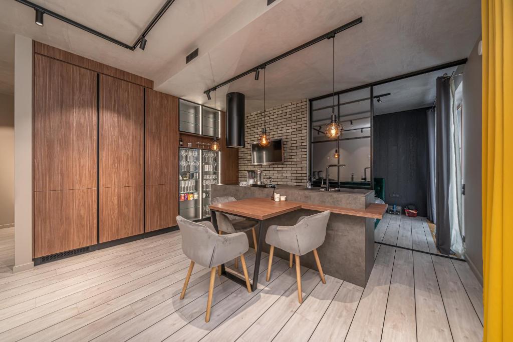a kitchen with a wooden table and chairs at Lofts & Rosegold Luxury Stay in Elegant 1BR with Balcony in Riga Center in Rīga