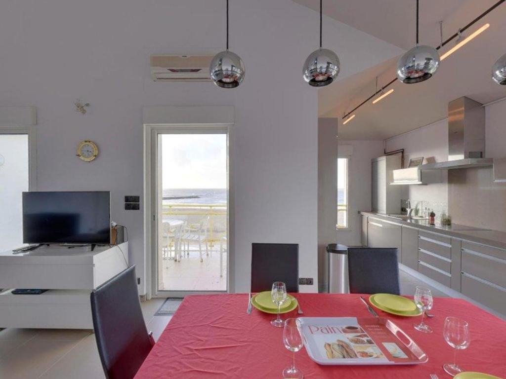 a kitchen and dining room with a red table and chairs at Appartement Châtelaillon-Plage, 4 pièces, 6 personnes - FR-1-706-11 in Châtelaillon-Plage