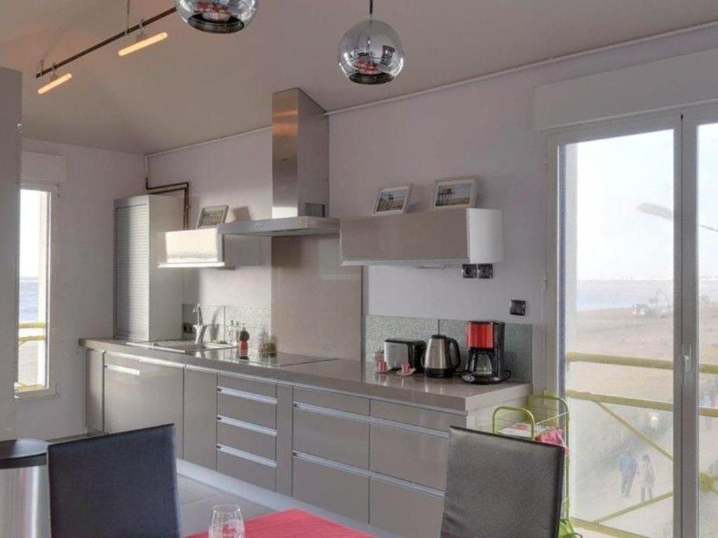 a kitchen with white cabinets and a large window at Appartement Châtelaillon-Plage, 4 pièces, 6 personnes - FR-1-706-11 in Châtelaillon-Plage