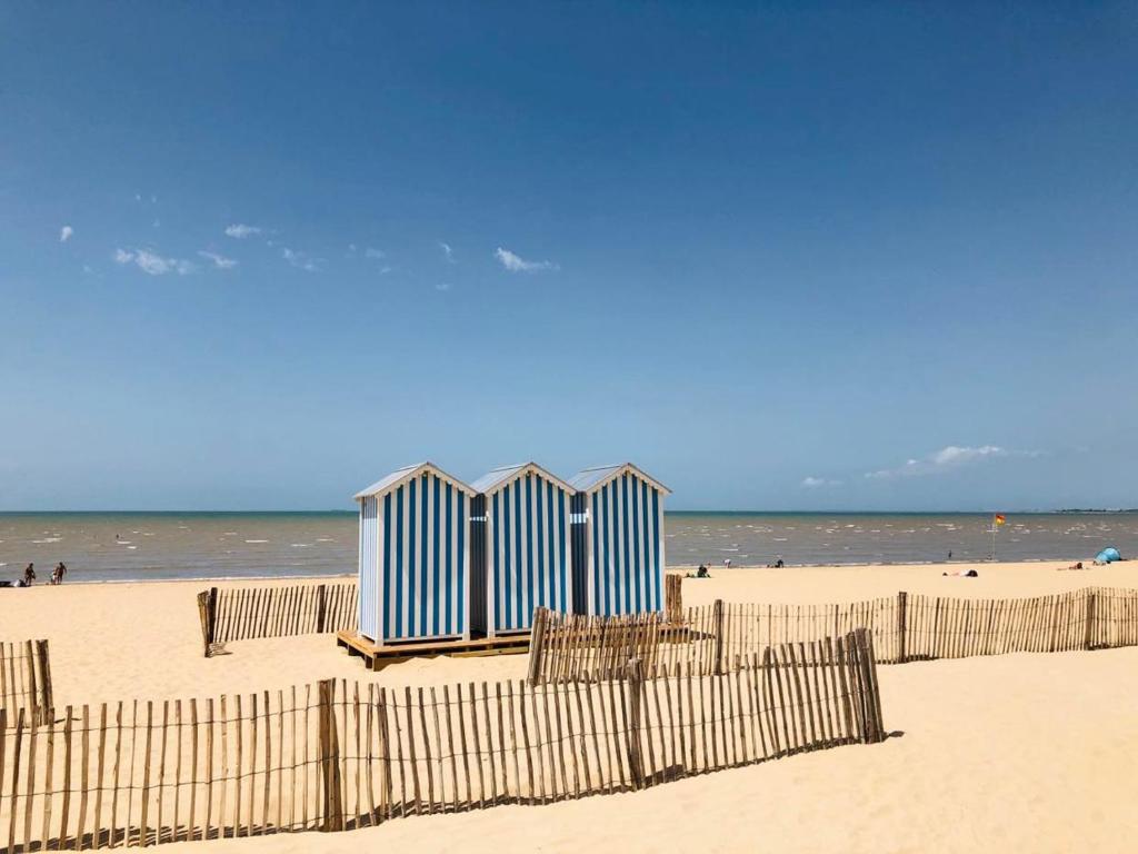 a group of blue beach huts on the beach at Appartement Châtelaillon-Plage, 4 pièces, 6 personnes - FR-1-706-11 in Châtelaillon-Plage