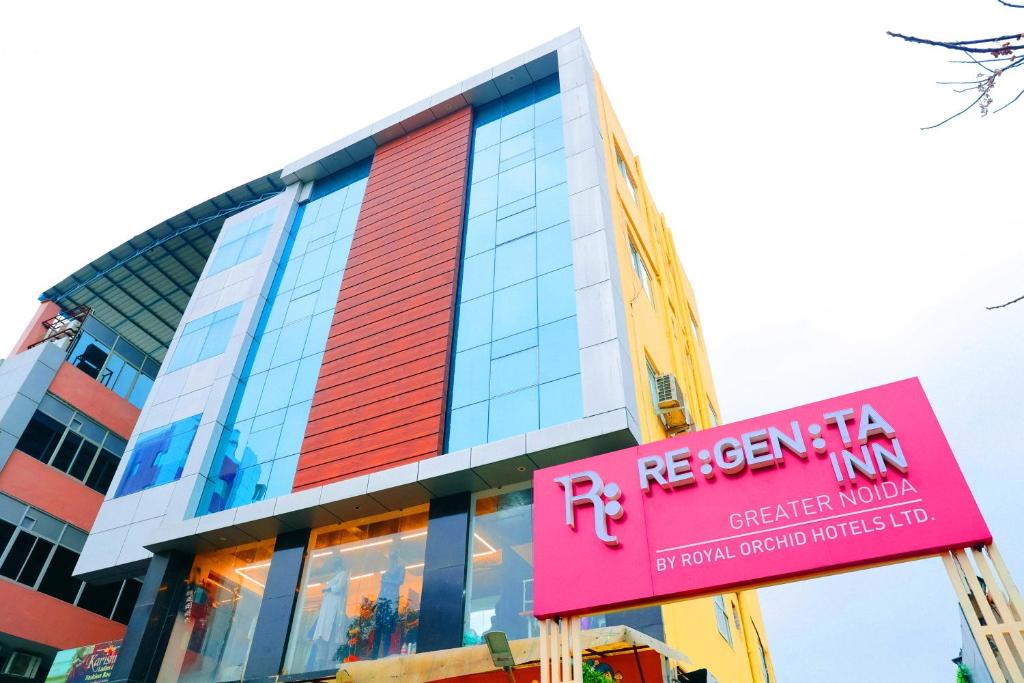 un edificio con un cartello rosa davanti di Regenta Inn Greater Noida, 15 Mins to India Expo Mart a Greater Noida