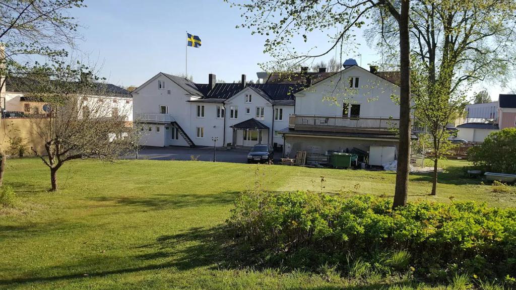 a large white house in a park with a yard at Gamleby Hotell in Gamleby
