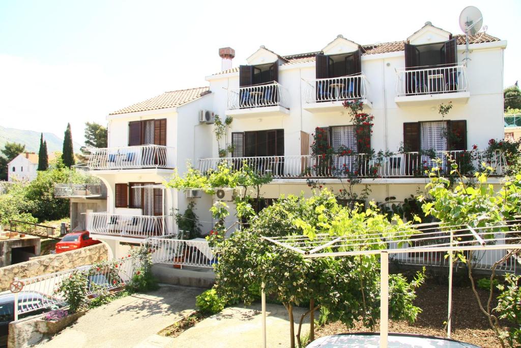 una casa blanca con balcones y árboles frente a ella en Villa Anka, en Cavtat