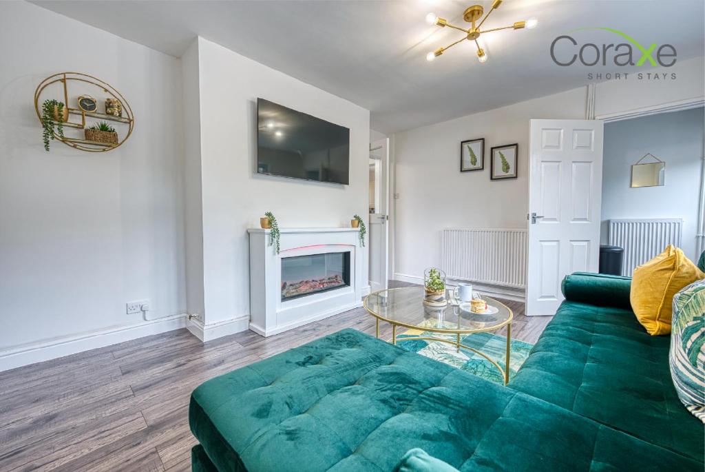 a living room with a green couch and a fireplace at 3 Bedroom Luxe Living for Contractors and Families by Coraxe Short Stays in Dudley