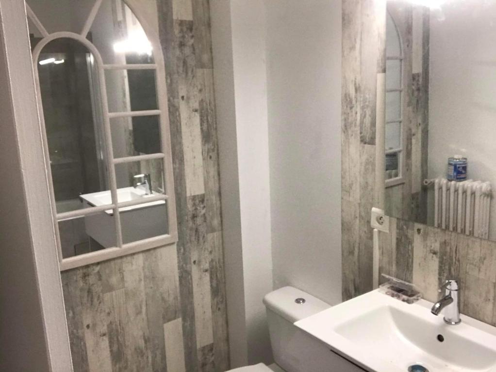 ein Badezimmer mit einem Waschbecken, einem WC und einem Spiegel in der Unterkunft Beau 2 pièces proche plage et commerces in Le Pouliguen