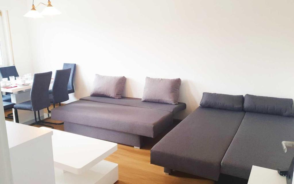 uma sala de estar com dois sofás e uma mesa em City-Apartment Heidelberg em Eppelheim