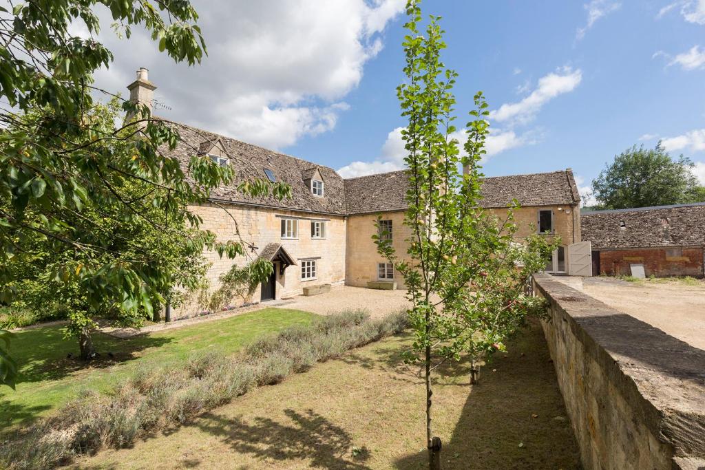 un albero di mele di fronte a un edificio di Almsbury Farmhouse a Winchcombe