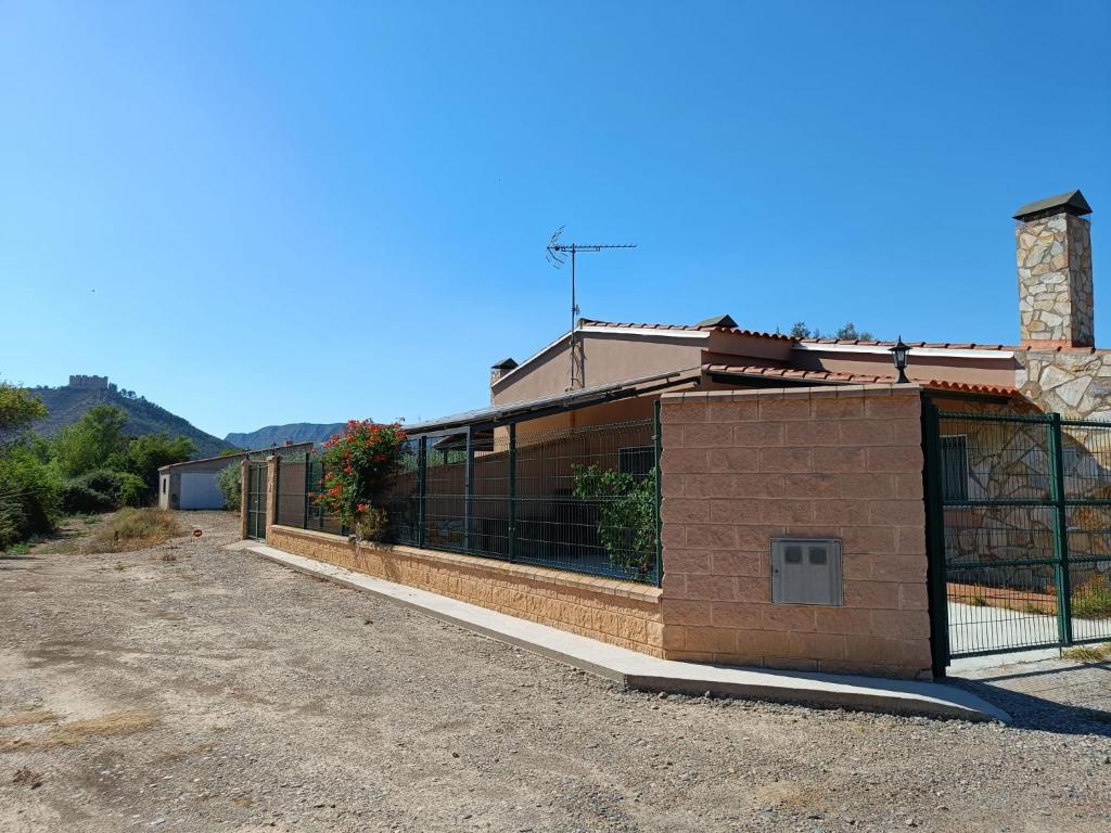 um edifício com uma cerca ao lado em Casa Mequinenza em Mequinenza