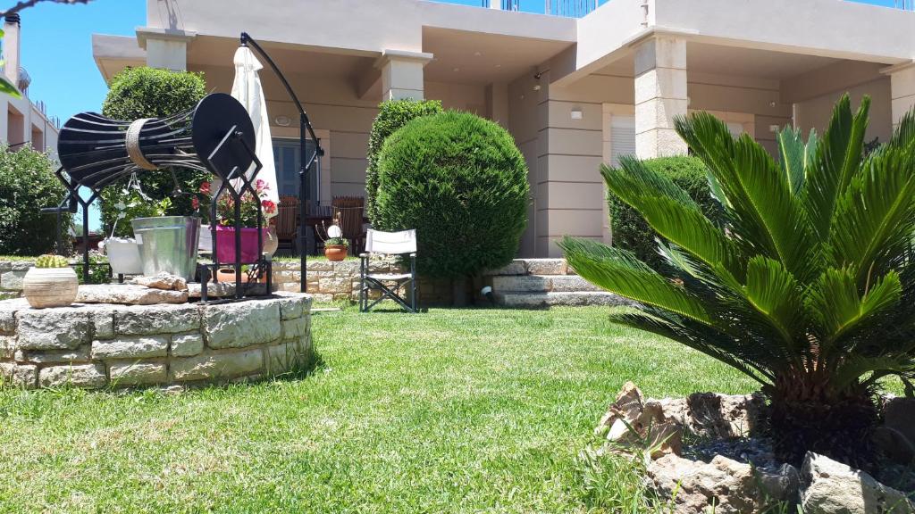 a house with a yard with a fountain in the grass at Modern Villa in Chania in Perivólia
