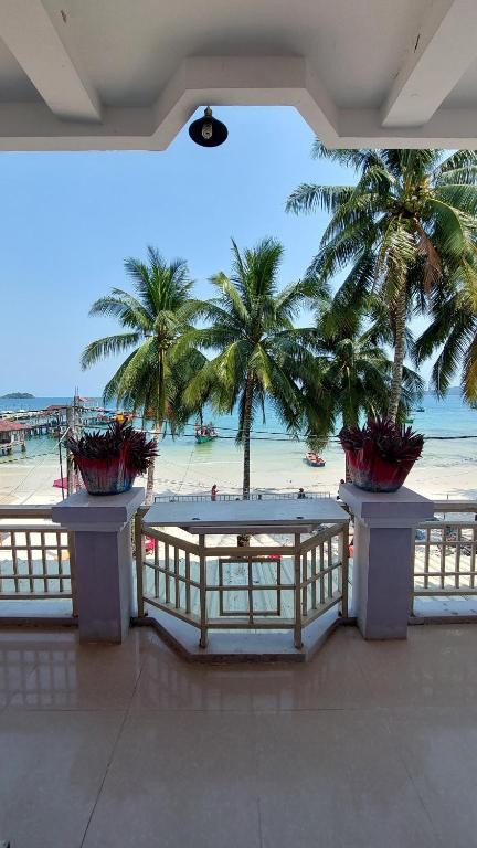 ロン島にあるISLANDS BOUTIQUE Koh Rongのヤシの木が植わるリゾートからビーチの景色を望めます。