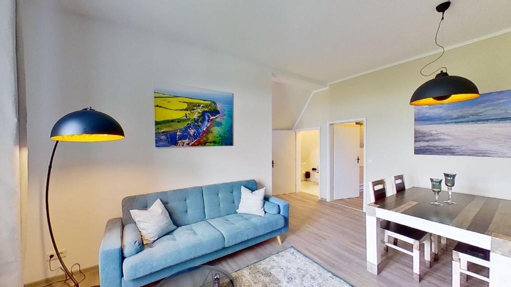 uma sala de estar com um sofá azul e uma mesa em Ferienwohnung Leuchtturmwärter em Putgarten
